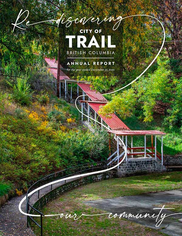 Wooden boardwalk winding through lush green forest in Trail, British Columbia, with text overlay about annual report.